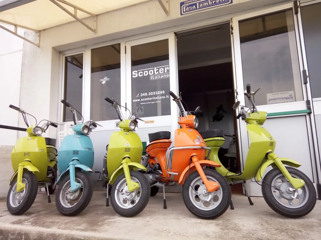 Cinque Lambretta Lui colorate davanti al negozio